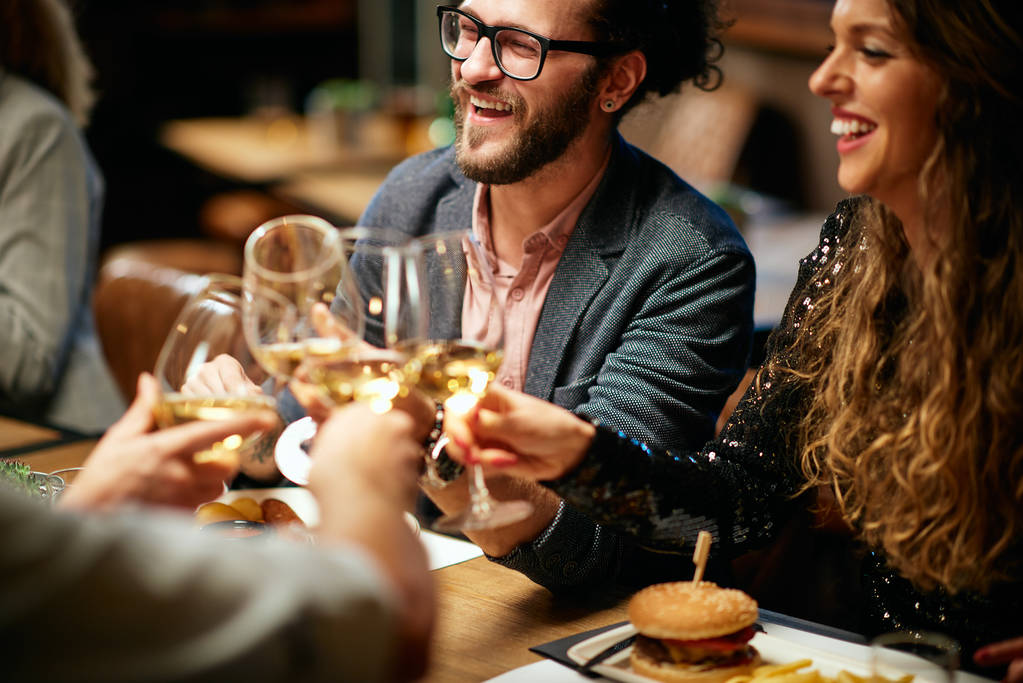 Best friends sitting in restaurant for dinner and making a toast foodie friends
